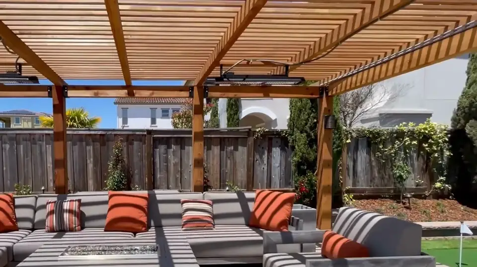 Shaded seating area under a wood pergola with red cushions